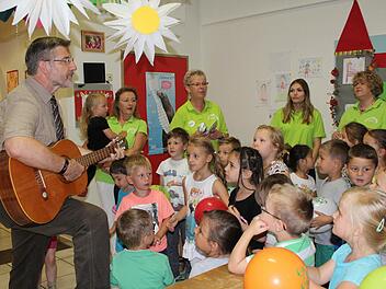 Landrat Michael Busch und die Kinder des ausgezeichneten Weidach-Kindergartens singen zusammen ein Lied. Foto: Manja von Nida
