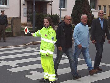 Julia Brendel geleitet diesmal nicht ihre Mitschüler, sondern Schulleiter Stefan Völker, den Vorsitzenden der Kreisverkehrswacht, Alfons Hrubesch, und ihren Vater Karl Brendel (von rechts) über die Straße.Alfred Thieret