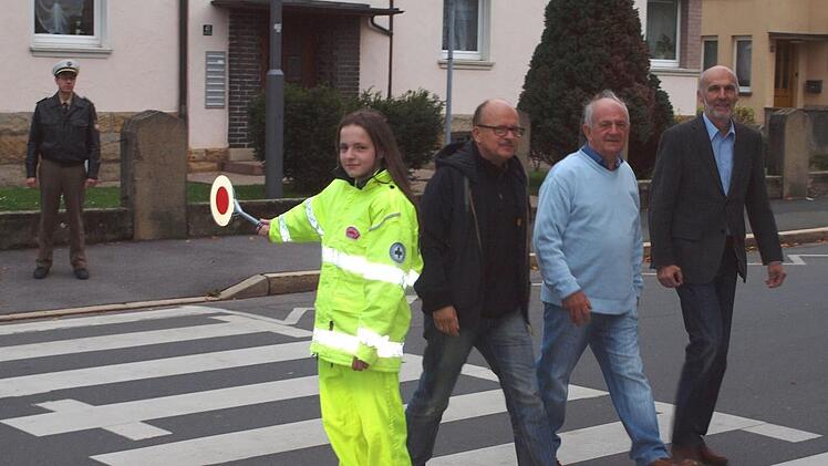 Julia Brendel geleitet diesmal nicht ihre Mitschüler, sondern Schulleiter Stefan Völker, den Vorsitzenden der Kreisverkehrswacht, Alfons Hrubesch, und ihren Vater Karl Brendel (von rechts) über die Straße.Alfred Thieret