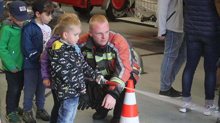 Holger Reinlein zeigte den Kindern, wie mit man mit einem Wasserstrahl zielen kann. Foto: Matthias Einwag
