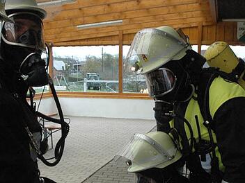 Drei Jugendliche waren gerettet, doch nun schwebte ein Feuerwehrmann selbst in Gefahr. Die Atemschutzträger brauchten bei der realitätsnah inszenierten Rettungsaktion mehr Luft, um den Mann samt seiner schweren Ausrüstung aus dem verqualmten Sportheim ins Freie zu bekommen.  Foto: Schmidt