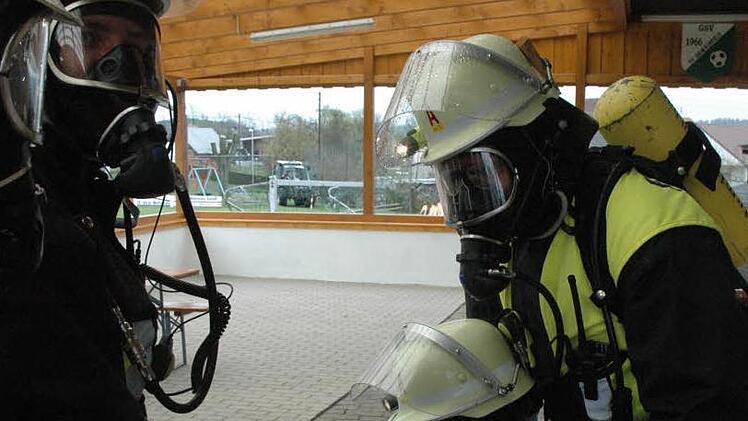 Drei Jugendliche waren gerettet, doch nun schwebte ein Feuerwehrmann selbst in Gefahr. Die Atemschutzträger brauchten bei der realitätsnah inszenierten Rettungsaktion mehr Luft, um den Mann samt seiner schweren Ausrüstung aus dem verqualmten Sportheim ins Freie zu bekommen.  Foto: Schmidt