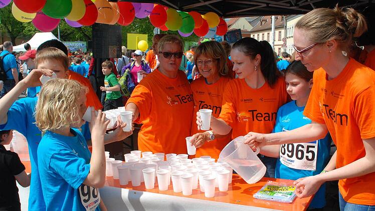 Irene Förtsch, Sigrid Sailmann, Christine Döhlemann, Lena Göler, Ute Nickel (von links) verbreiten am Stand der Diakonie im Startbereich nicht nur Wasser, sondern auch gute Laune an die Welterbeläufer. Foto: Günter Flegel