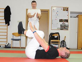 Sensei Helmut erklärt Schüler Christoph im Dojo (Trainingsraum) in Roßfeld, dass er die Arme bei der Übung parallel bewegen soll. Foto: Natalie Schalk