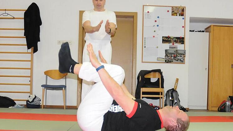 Sensei Helmut erklärt Schüler Christoph im Dojo (Trainingsraum) in Roßfeld, dass er die Arme bei der Übung parallel bewegen soll. Foto: Natalie Schalk