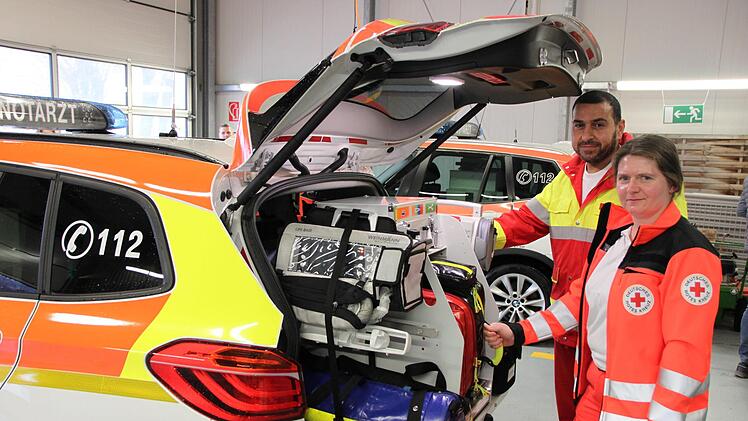 Notarzt Tarek El-Qarm steht mit einer Kollegin am Heck des Fahrzeuges und demonstriert das ärztliche Equipment. Foto: Hilmar Ruppert