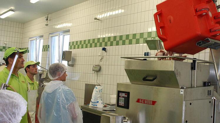 Auf Knopfdruck fährt die Maschine den Behälter mit dem Fleisch nach oben und kippt dieses in den Fleischwolf.