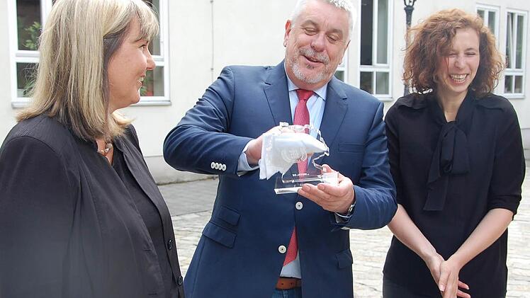 OB Norbert Tessmer griff nach der Verleihung zum Poliertuch und brachte den gläsernen Preis noch mehr zum Glänzen. Links Bürgermeisterin Birgit Weber, rechts Franziska Gläsing (hotel.de). Foto: Oliver Schmidt