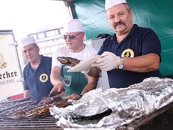 Die Bad Kissinger Sportangler heizen den Rakoczy-Besuchern beim Makrelen-Grillen im Rosengarten ordentlich ein. Foto: Teresa Hirschberg