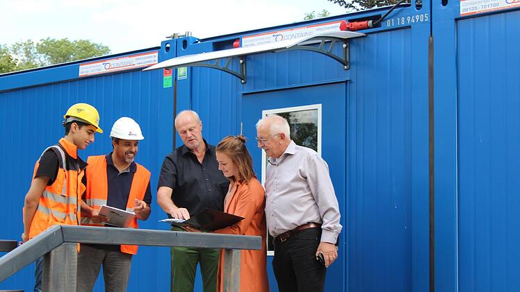 Die Schadstoffexperten (links) und die Architekten Wiesneth (rechts) mit Bürgermeister Brehm (Mitte) vor dem Kindergarten-Container