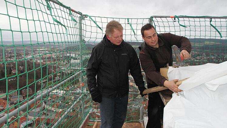Droben auf dem Wachturm der Kulmbacher Plassenburg pfeift der Wind so kalt: Hier müssen Bastian Sandler und sein Chef Günther Stenglein (links) schauen, dass die Schutzplanen gut befestigt sind. Die Zimmerer der Firmen Stenglein und Eber reparieren am höchsten Punkt der Burg das hölzerne Innenleben des Turmhelms. Foto: Stephan Tiroch