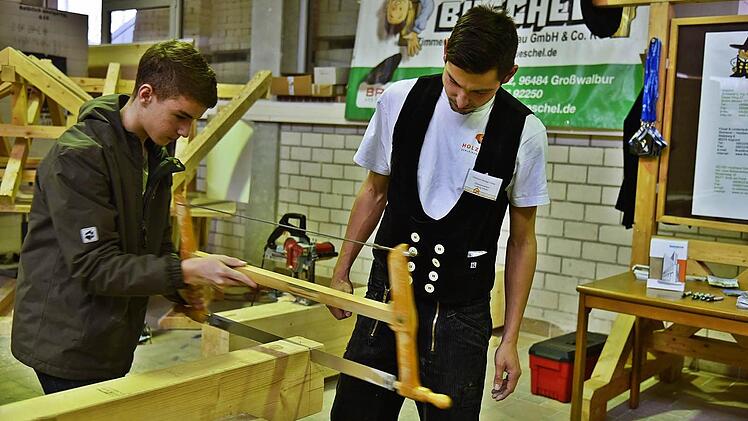 Zimmermeister Ludwig Scheler dürfen die Späne fliegen, André Horn probiert es aus. Foto: Gabi Arnold