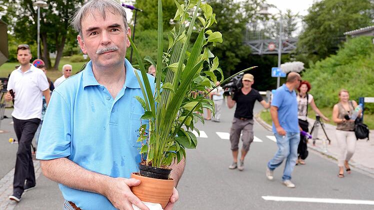 Gustl Mollath verlässt am 6.August.2013 mit einer Topfpflanze in der Hand das Bezirkskrankenhaus in Bayreuth.  Foto: Ebener/dpa