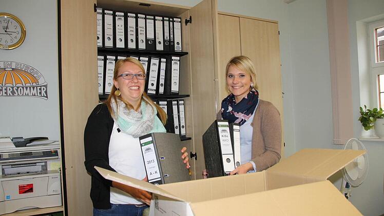 Sabrina Geis und Alin Schulz-Stellmacher vom Kissinger-Sommer-Büro räumen Ordner mit Kissinger-Sommer-Logo in die Umzugskartons. Fotos: Ralf Ruppert