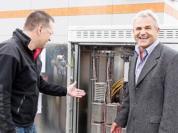 Ludwig Nagel von der Telekom (rechts) und Bürgermeister Karsten Fischkal vor dem Multifunktionsgehäuse  Foto: Johanna Blum
