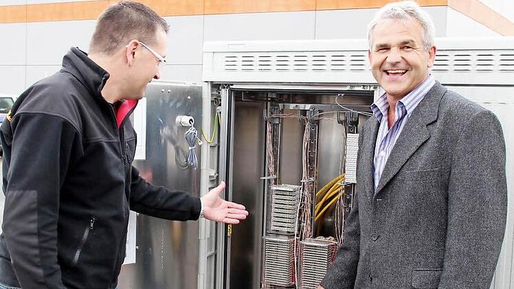Ludwig Nagel von der Telekom (rechts) und Bürgermeister Karsten Fischkal vor dem Multifunktionsgehäuse  Foto: Johanna Blum