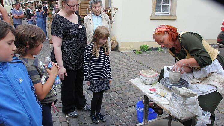 Die Töpferin erklärt ihre Handwerkskunst.