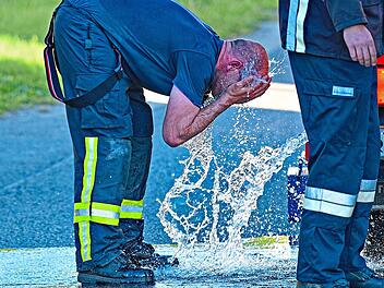 Ein Feuerwehrmann k&uuml;hlt sich bei einem Einsatz ab.SMS|Schalk, Manfred, Schrobenhausen