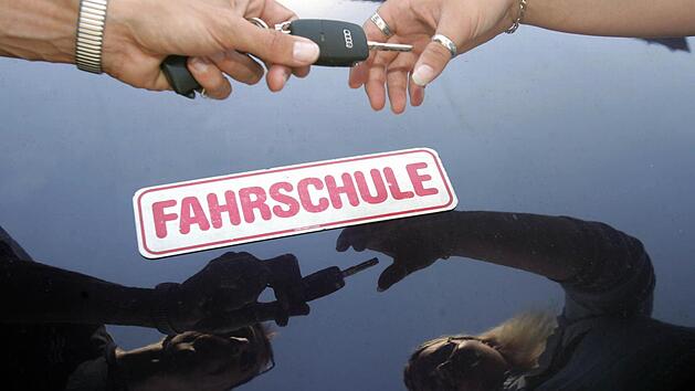 ARCHIV - Ein Fahrlehrer überreicht seiner Fahrschülerin am 13.07.2005 den Schlüssel zum Fahrzeug im oberfränkischen Michelau. Jedes Jahr fallen in Deutschland Hunderttausende durch die Führerscheinprüfung. Der Autoclub Europa ACE macht dafür eine mangelhafte Vorbereitung in den Fahrschulen verantwortlich. Foto: Marcus Führer/dpa