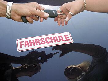 ARCHIV - Ein Fahrlehrer überreicht seiner Fahrschülerin am 13.07.2005 den Schlüssel zum Fahrzeug im oberfränkischen Michelau. Jedes Jahr fallen in Deutschland Hunderttausende durch die Führerscheinprüfung. Der Autoclub Europa ACE macht dafür eine mangelhafte Vorbereitung in den Fahrschulen verantwortlich. Foto: Marcus Führer/dpa