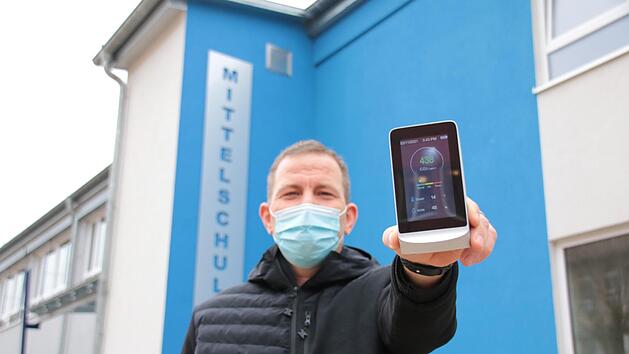 Draußen vor der Schule ist natürlich alles im grünen Bereich: Hausmeister Jörg Schröter zeigt eines der Kohlendioxid-Messgeräte, die die Stadt aktuell für die Grund- und die Mittelschule anschafft. Bis zu einem Anteil von 800 Teilchen pro einer Million (ppm) steht die Ampel auf grün, zwischen 800 und 1200 ppm auf orange, darüber springt die Anzeige auf rot und es muss gelüftet werden. Foto: Ralf Ruppert