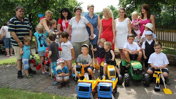 Die Elternbeiratsvorsitzende Daniela Hirschlein (Vierte von links) überreichte die kleinen Fahrzeuge an die Leiterin des Kindergartens Manuela Käb (Dritte von links). Die Kinder freuten sich riesig über das Geburtstagsgeschenk und nahmen die Spielsachen sofort in Beschlag. Foto: Michael Stelzner