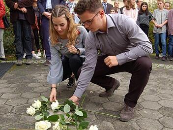 Samira Eberth und Tim Culmbacher legen ihre Rosen am Stolperstein für Edith Frank nieder. Foto: Helke Renner