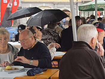 Die Coburger rücken unter den Schirmen zusammen und trotzen so dem Regen am Samstagabend - der Kloß schmeckt trotzdem.  Fotos: Daniela Pondelicek