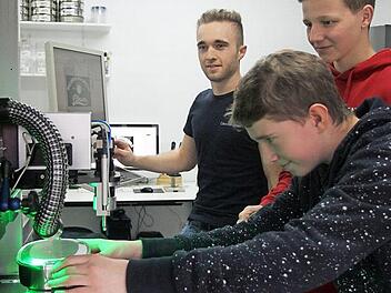 Philipp Muth bei der Arbeit an der Lasermaschine mit Simon Schlee und Wirtschaftspaten Adrian Dümpert von der Firma Ceratonia (von rechts). Fotos: Günther Geiling