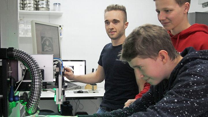 Philipp Muth bei der Arbeit an der Lasermaschine mit Simon Schlee und Wirtschaftspaten Adrian Dümpert von der Firma Ceratonia (von rechts). Fotos: Günther Geiling
