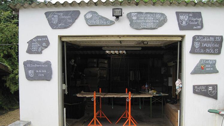 An der Werkstatt im Friedhof haben Gruppen, die hier schon Einsätze geleistet haben, Erinnerungstafeln angebracht. Foto: Paul Ziegler