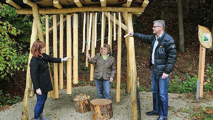 Lissy D&ouml;rfler-Christa (von links), Katrin Schnabel und B&uuml;rgermeister Wolfgang M&ouml;hrlein bei der Station 12, dem Klangobjekt. Auf h&ouml;lzernen &Auml;sten kann man hier "Musik" machen. Foto: Rarald Rieger