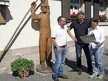 Zusammen mit Bürgermeister Norbert Gräbner (l.) machen sich Markus Schäfer und Yvonne Slanz ein Bild von Marktrodach. Hier begutachten sie das Flößermuseum und den "schweren Max", ein Standbild eines Flößers. Foto: Susanne Deuerling