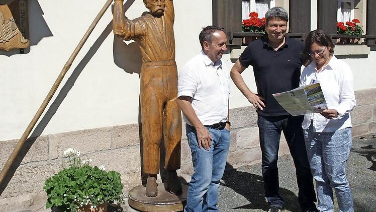 Zusammen mit Bürgermeister Norbert Gräbner (l.) machen sich Markus Schäfer und Yvonne Slanz ein Bild von Marktrodach. Hier begutachten sie das Flößermuseum und den "schweren Max", ein Standbild eines Flößers. Foto: Susanne Deuerling
