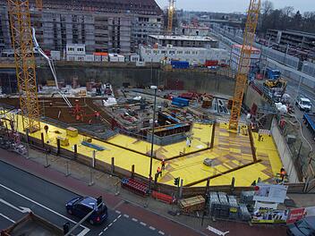 Blick vom Arcaden-Parkhaus auf die fast acht Meter tiefe Baugrube des neuen Landratsamtes in Erlangen. Wo gelbe Bretter liegen, werden später in der Tiefgarage die Autos fahren. Foto: Christian Bauriedel