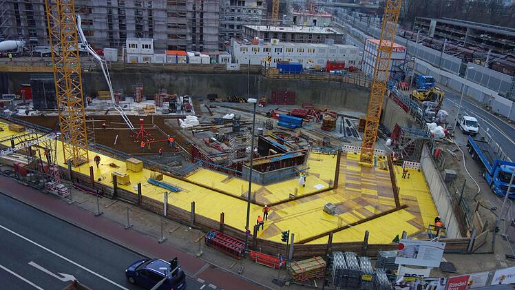 Blick vom Arcaden-Parkhaus auf die fast acht Meter tiefe Baugrube des neuen Landratsamtes in Erlangen. Wo gelbe Bretter liegen, werden später in der Tiefgarage die Autos fahren. Foto: Christian Bauriedel