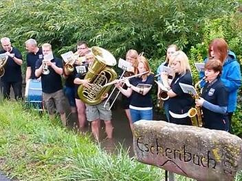 Am Eschenbach-Stein: Die Musiker spielten im Eschenbach stehend und lösten so ihre Wette ein. Foto: Verena Hebig