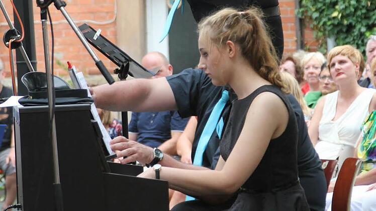 Sophie Angermann begleitete sicher und zuverlässig den Chor am Klavier. Hinten Chorleiter Jörg Schmidt.