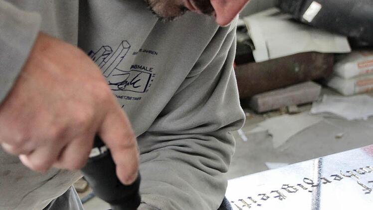 Bildhauer Tomas Rückl beim Gravieren.