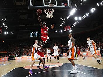 Der Bamberger Dawan Robinson zieht zwischen den Ulmern Boris Savovic (l.) und Will Clyburn (r.) hindurch zum Korb und erzielt zwei Punkte.  Foto: Daniel Löb