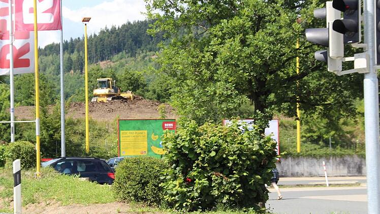 Unmittelbar hinter dem Rewe-Parkplatz in Stadtsteinach haben am Mittwoch die Bauarbeiten am neuen Markt begonnen. Die Firma Günther-Bau schiebt dort den Mutterboden des Baugrunds ab. Foto: Matthias Beetz