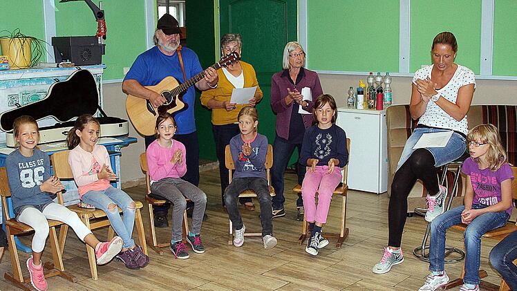 Jeder Tag wird mit dem "Lagerboggi" eröffnet, den Peter Iberl (Links im Hintergrund) auf seiner Gitarre spielt. Neben ihm Rosalinde Heider, Christine Müller und Stefanie Schäfer.  Foto: Dieter Britz