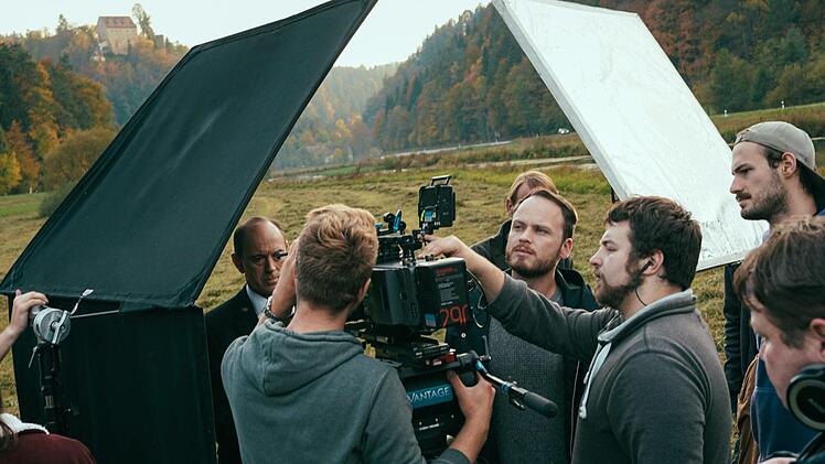 Das "Todsicher"-Filmteam bereitet die nächste Einstellung vor. Die Burg Rabeneck thront im Hintergrund. Foto: Lisa Weixelbaum