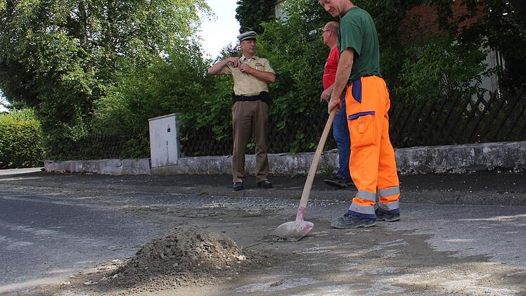 Mitarbeiter des Bauhofs schaufelten das Baumaterial von der Straße. Foto: Andreas Dorsch