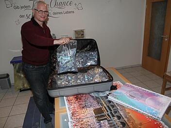 Peter Schubert hat bereits 28.000 von 48.000 Teilen gelegt. Das weltgrößte Puzzle war in 24 Beuteln zu je 2000 Teilen in einem Reisekoffer versendet worden. Foto: Mathias Erlwein