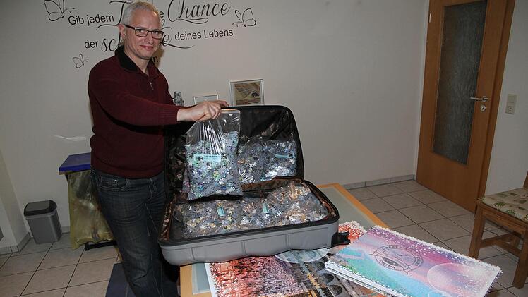 Peter Schubert hat bereits 28.000 von 48.000 Teilen gelegt. Das weltgrößte Puzzle war in 24 Beuteln zu je 2000 Teilen in einem Reisekoffer versendet worden. Foto: Mathias Erlwein