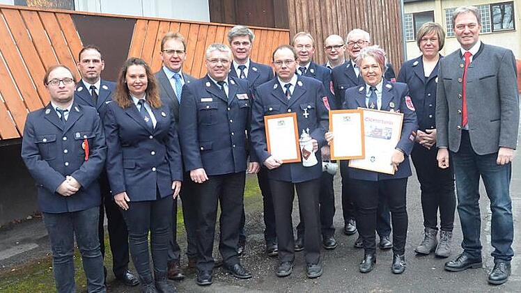 Dem neue n Kommandanten Thomas Ultsch (vorne Vierter von links) und seiner Vorgängerin Monika Butz (vorne Fünfte von links) wurde für 25-jährige aktive Dienstzeit das staatliche Ehrenzeichen in Silber verliehen. Monika Butz wurde zudem zur Ehrenkommandantin ernannt. Mit im Bild Landrat Klaus Löffler (rechts), KBI Matthias Schuhbäck (vorne Dritter von links), KBM Markus Reischl (zweite Reihe links) und Bürgermeister Bernd Rebhan (zweite Reihe Zweiter v.l.) sowie Vorsitzender Hermann Müller (zw...