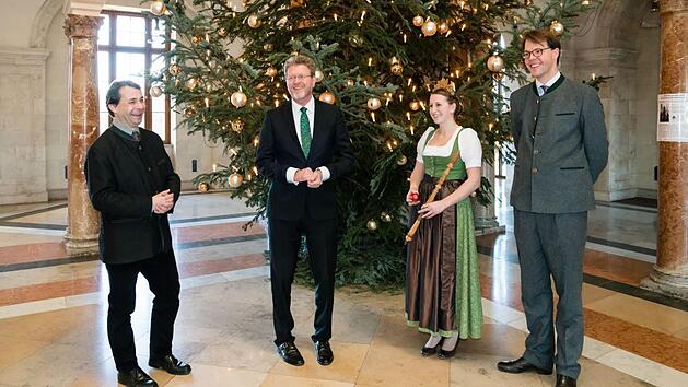 Glanz f&uuml;r die Staatskanzlei: Bei der &Uuml;bergabe des Christbaumes posieren der Pr&auml;sident des Bayerischen Waldbesitzerverbandes Josef Ziegler, Staatsminister Marcel Huber, Waldk&ouml;nigin Anna Maria Oswald und Maximilian Freiherr von Rotenhan (von links), der Spender der Wei&szlig;tanne, f&uuml;r die Kamera. Foto: Rolf Kaul