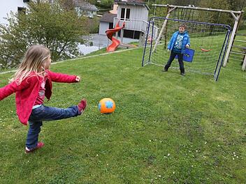 Der Rasen ist sicherlich die wichtigste Pflanze im Familiengarten. Hier testet die kleine Elena die Torwartkünste ihres achtjährigen Bruders Christopher. Foto: Barbara Herbst