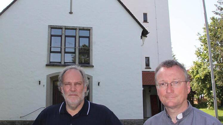 Pfarrer Thomas Wagner (rechts) und Kirchenpfleger Jos Flieser vor der 60 Jahre alten katholischen Kirche in Thurnau.  Fotos: Jürgen Gärtner